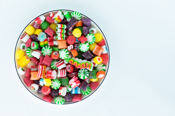 Top down view of a bowl of Christmas candies isolated against a white background. - obrazy, fototapety, plakaty