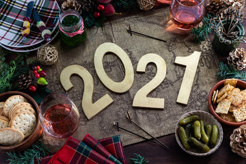 Top down view of an arrangement of festive foods and decorations with 2021 in the centre. New Year...