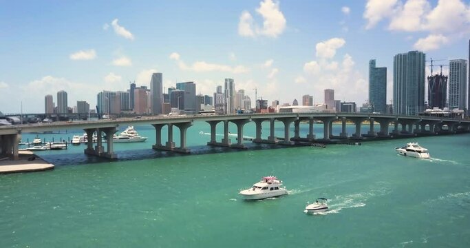beautiful aerial shot of miami skyline with the bay, boats, and a bridge