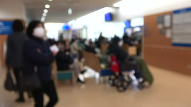 ぼかし背景素材 マスクを付けた患者で満席の病院のロビー  4K  2020年12月 日本にて撮影