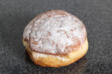 Doughnut without a hole filled with jam with sugar on top