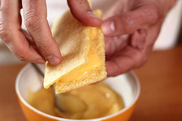 Making sandwich with corn crispbread. Making mayonnaise with a wooden spoon.