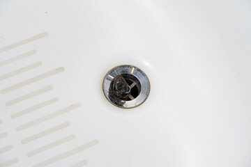 cleaning the clogged bathroom drain.