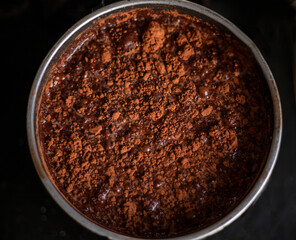 cook cocoa powder with milk in a bowl on a black background, food