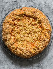 Caramelized pumpkin cinnamon crumble pie on a grey background, top view