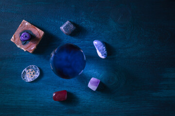 Divination. A magic ball, shot from the top with crystals and a candle on a dark background, with a...