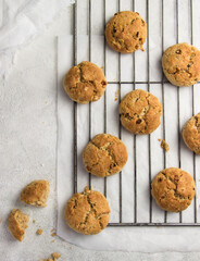 oatmeal cookies. Healthy and crunchy homemade dessert made of fresh grated carrot, raisins and rolled oats decorated with chocolate.  White background, orange biscuits. Top view, copy space.
