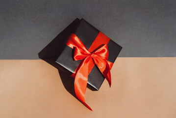 Gift with a large red bow on a gray-beige background.