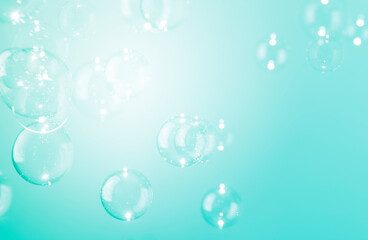 Transparent soap bubbles float on green background.