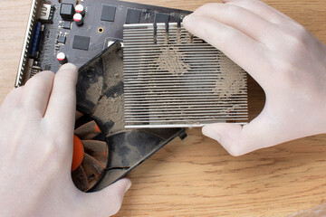 Repair of a modern computer, cleaning the components of a video card from dust.