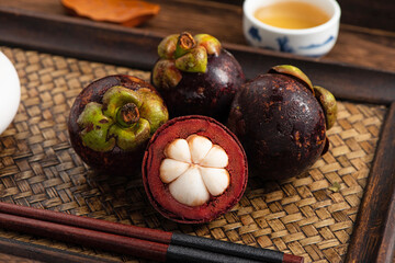 Fresh fruit mangosteen on the background of retro Chinese style tea tray