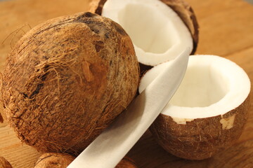 a whole coconut and a sliced coconut on a wooden table