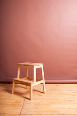 Wooden technical stool on a brown background in a photo Studio. Paper photophone.