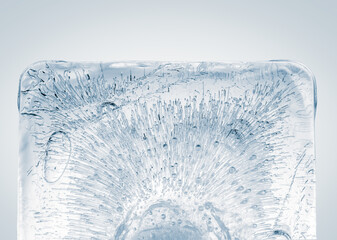 Clean rectangular transparent piece of ice with air bubbles on white background.