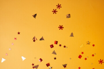 Christmas sparkles in the form of a Christmas tree, gifts, stars on a yellow background. High quality photo