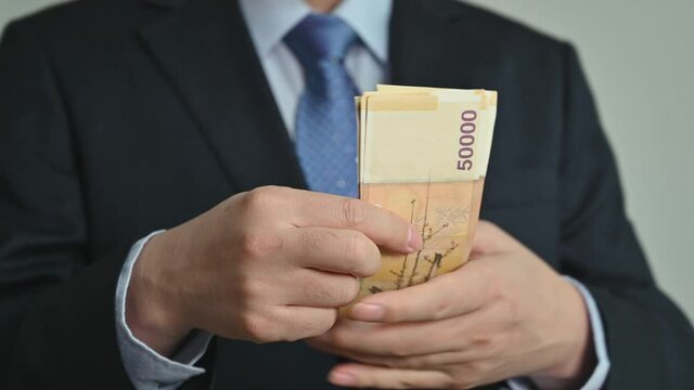 Businessman holding Korean currency in hand