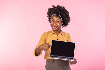 Excited african girl holding laptop with black screen. Happy business woman pointing with finger on the screen of laptop. Advertising concept