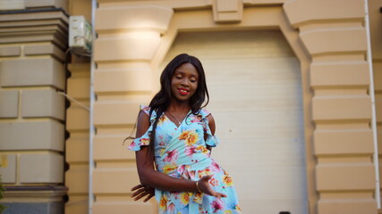 Joyful afro girl dancing on street. Lady making rhythmical moves in city