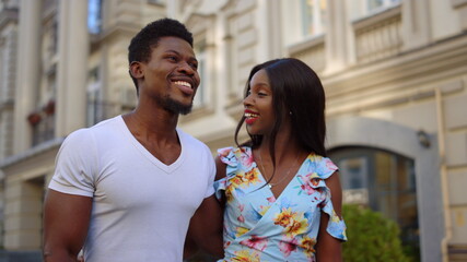 Afro couple having romantic date outdoors. Man and woman walking in city