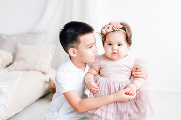 My brother holds my little sister's hand and hugs her. Happy happy children, on a nice soft background