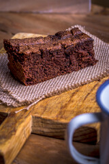 Piece of chocolate cake on a wooden table.