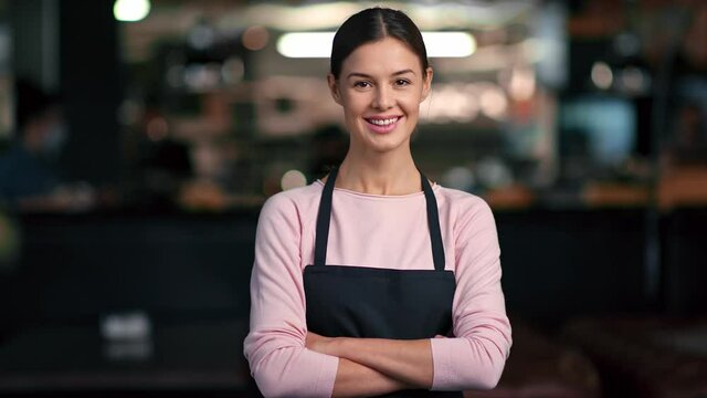 Portrait of friendly smiling woman in apron worker of cafe posing. Medium shot on RED camera