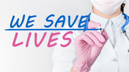 Close up female doctor writing words - We save lives with marker. Medical concept