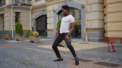 Handsome afro man dancing latino dance outdoors. Sexy afro guy dancing bachata