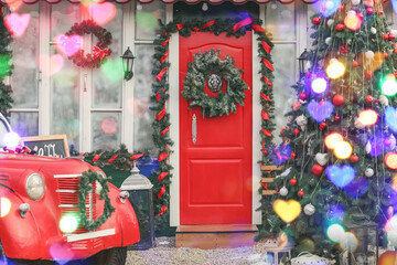 Car and fir tree near house decorated for Christmas