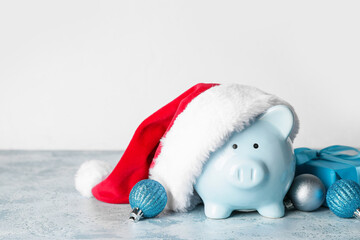 Santa hat with piggy bank and Christmas decor on table