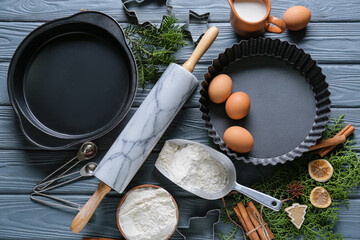 Ingredients for Christmas bakery and kitchen utensils on grey wooden background