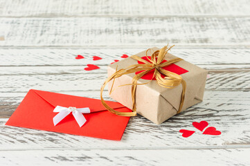 Valentines Day gift box with envelope with love letter, paper hearts on wooden background. greeting card for valentines day or birthday.