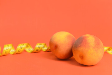 Fresh juicy peaches and measuring tape on color background. Breast augmentation concept