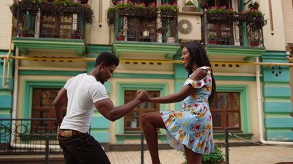 Happy african dancers curling in dance in city. Afro couple dancing on street