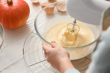 Woman preparing pumpkin pie on table