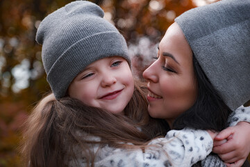 Obraz premium Mother and daughter walking in the park and enjoying autumn nature.