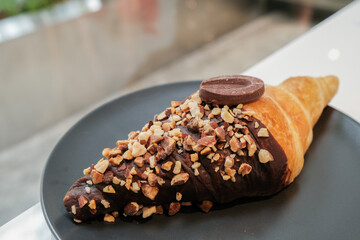 chocolate croissant on black dish in cafe