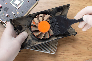 Repair of a modern computer, cleaning the components of a video card from dust.