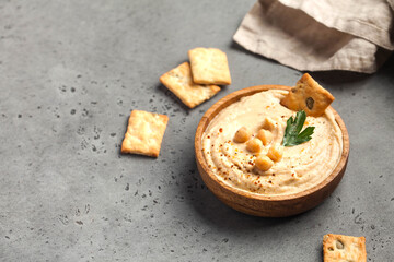 hummus in a wooden plate with parsley and croutons. Dishes of chickpeas, a vegetarian dish. Copy space.
