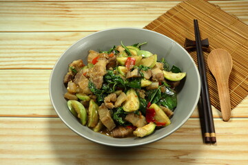 Fried and stirred spicy chopped eggplant with cutting belly pork, basil and chilly on the plate. Famous traditional menu in Asian restaurant. 