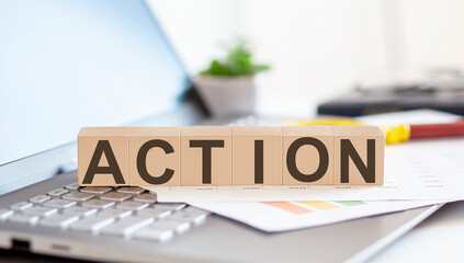 ACTION Wooden cubes with letters on a laptop keyboard.