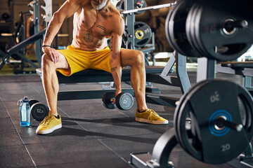 Male bodybuilder toning his biceps with a strength exercise