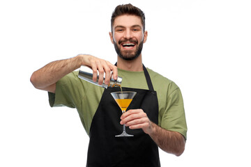alcohol drinks, people and job concept - happy smiling barman in black apron with shaker and glass preparing martini cocktail over white background