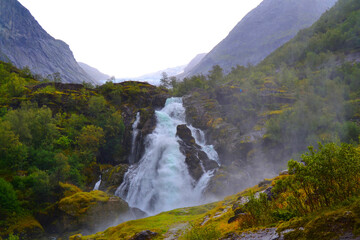 Obraz na płótnie Canvas Beautiful waterfall in the Jostedalsbreen National Park in Norway. Pathway to Briksdal or Briksdalsbreen glacier in Olden. 