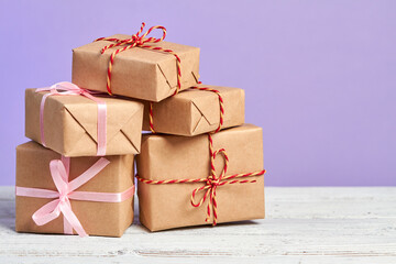 Christmas or New Year gift boxes on wooden surface against a purple background. Close-up, selective...