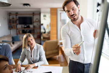 Portrait of young businessman with colleagues in office