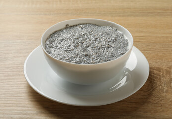 Bowl with chia pudding on wooden background