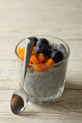 Glass with chia pudding on wooden table