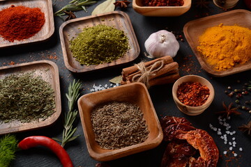 Variety of spices and herbs on kitchen table. Colorful various herbs and spices for cooking on dark background