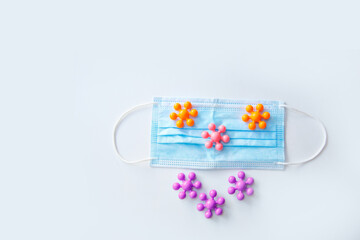 development of the game in the period of the pandemic. Health and recreation concept of family safety in the context of the covid-19 coronavirus pandemic. the medical mask on the multi-colored toys